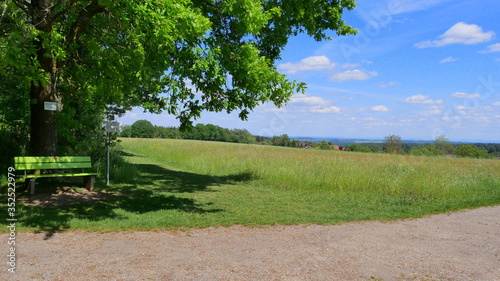 Panoramablick  auf die schwäbische Alb, Balinger Berge und Hohenzollern mit dem Panorama des Erholungsortes Oberlengenhardt im Vordergrund sowie einer Sitzbank unter einer Traubeneiche photo