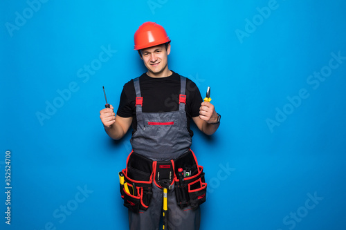 Portrait of a work repairman raising a hummer isolated on a blue background © F8  \ Suport Ukraine