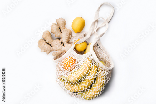 Package-free food shopping. Reusable string shopping bag with banana, orange, apple, lemon and ginger. Zero waste concept.