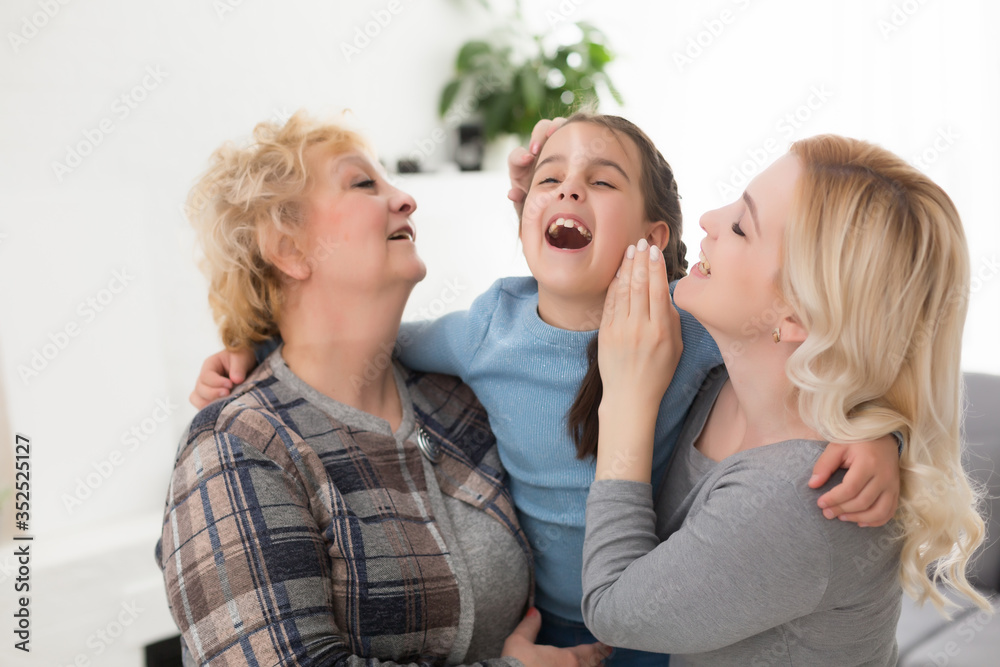 Portrait of three generations of women look at camera posing for family picture, cute little girl hug mom and granny enjoy time at home, smiling mother, daughter and grandmother spend weekend together Portrait of three generations of women look at camera posing for family picture, cute little girl hug mom and granny enjoy time at home, smiling mother, daughter and grandmother spend weekend together