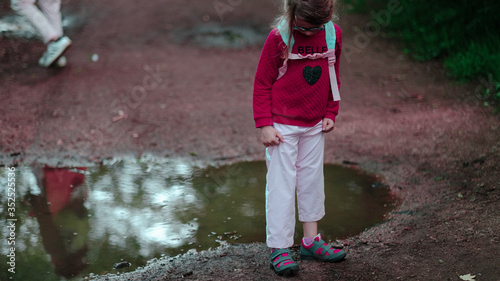 Fillette mignonne en balade hésite en regardant ses chaussures photo