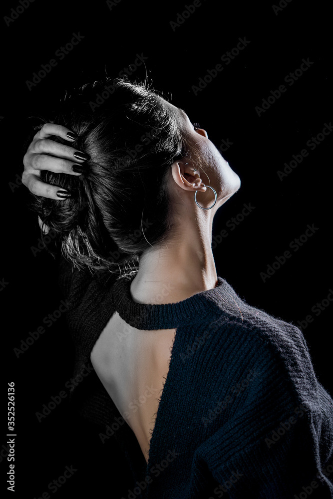 Close-up detail photo of young woman wearing open back blouse on black background. Colorful, black and white. Creative concept.