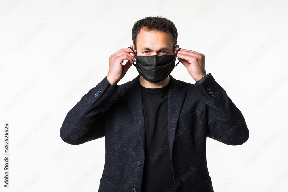 Young businessman is trying on a medical mask in the midst of a coronavirus pandemic isolated on white background