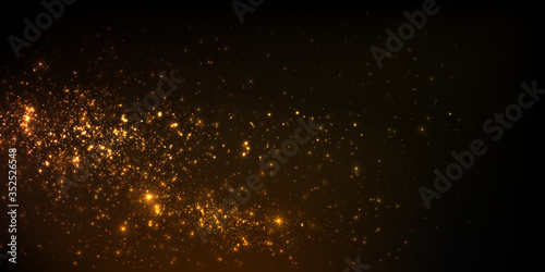 Sparkling golden particles on black background 