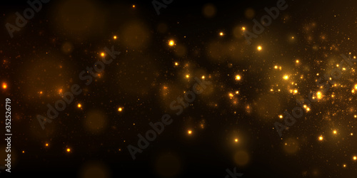 Sparkling golden particles on black background 
