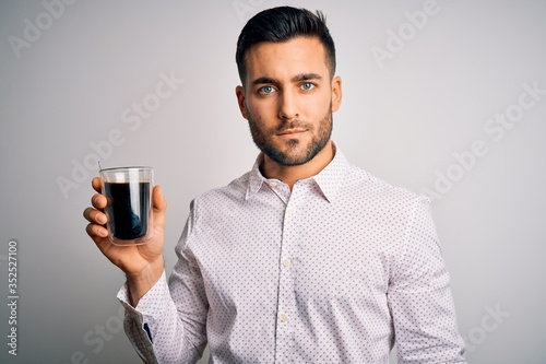 Young handsome man drinking a cup of hot coffee over white isolated background with a confident expression on smart face thinking serious
