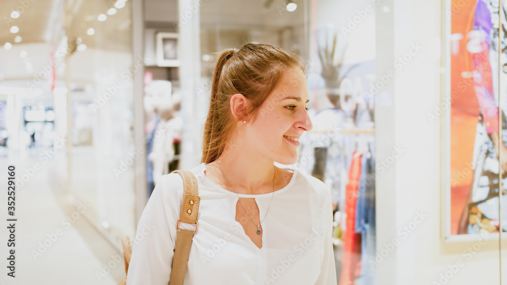 Portrait of young beautiful woman walking in shopping mall during season sale Portrait of young beautiful woman walking in shopping mall during season sale