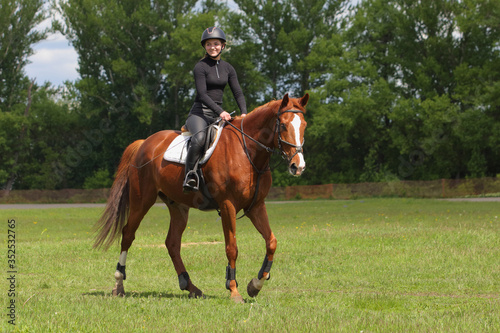 Equestrian model girl riding sportive dressage horse in summer fields © horsemen