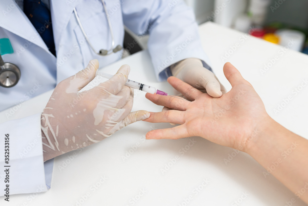 Asian doctor or nurse hands with syringe injecting to palm medical. Carpal tunnel syndrome, arthritis, neurological disease concept. Numbness of the hand Asian doctor or nurse hands with syringe injecting to palm medical. Carpal tunnel syndrome, arthritis, neurological disease concept. Numbness of the hand