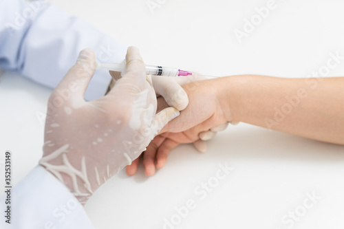 Bilde på lerret Asian doctor or nurse hands with syringe injecting to wrist medical