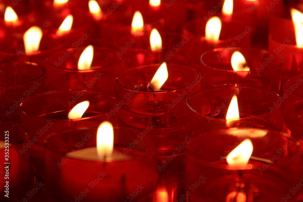 Velas rojas encendidas en una iglesia foto de Stock | Adobe Stock