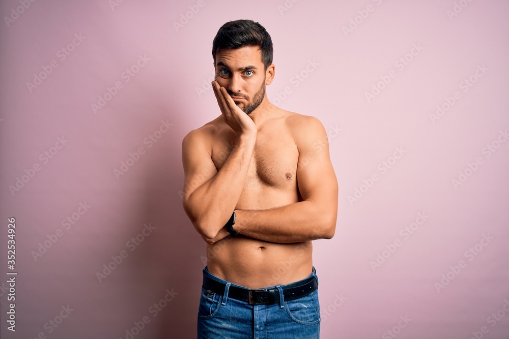 Young handsome strong man with beard shirtless standing over isolated pink background thinking looking tired and bored with depression problems with crossed arms.