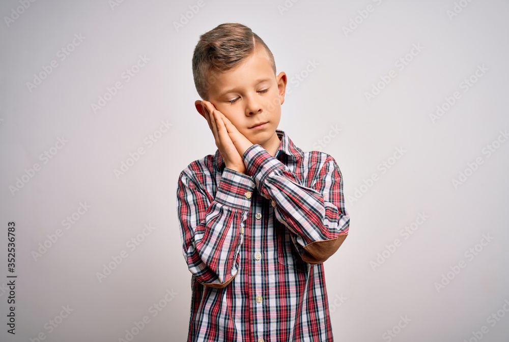 Young little caucasian kid with blue eyes wearing elegant shirt standing over isolated background sleeping tired dreaming and posing with hands together while smiling with closed eyes. Young little caucasian kid with blue eyes wearing elegant shirt standing over isolated background sleeping tired dreaming and posing with hands together while smiling with closed eyes.