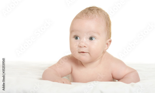 Cute baby girl posing on white blanket at home
