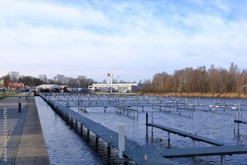 Obraz premium Boat Dock and Basin Marina Empty Awaiting Boating and Shipping Season on Water, Lake and River in Werder/Havel, Brandenburg, Germany in Europe
