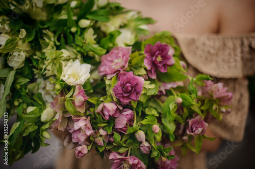 close-up of pink and white flowers and greenery in the hands of girl