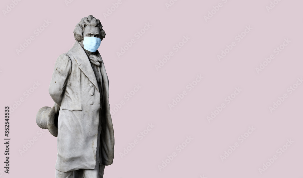 Ancient human statue wearing face mask against coronavirus COVID-19