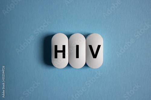 The inscription HIV on white tablets on a blue background. Human immunodeficiency virus concept.