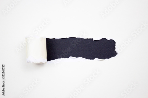 Torn white paper with jagged edges horizontally on a black background for your text.