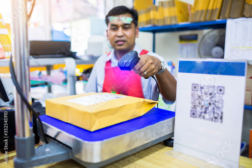 Selective focus to barcode reader in hand of staff in post office.