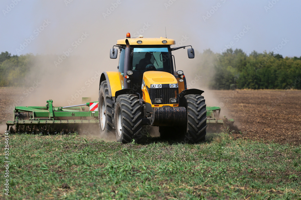 Tractor plows the field in the spring. Front view Tractor plows the field in the spring. Front view