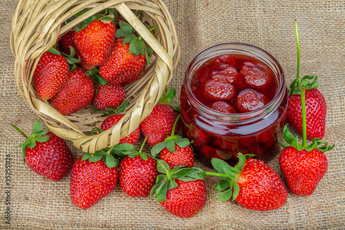 Naturel strawberries jam in a glass jar and fresh strawberriess 