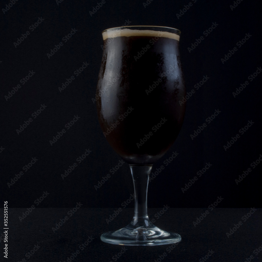 This bowl is made of crystal. The beer is a Dry Stout with grape must Tannat, Cabernet Franc, and Petit Verdot. Photo produced in low light, black background, lower exposure.