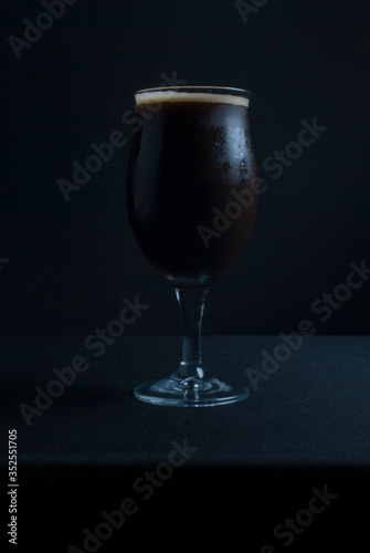 This bowl is made of crystal. The beer is a Dry Stout with grape must Tannat, Cabernet Franc, and Petit Verdot. Photo produced in low light, black background, lower exposure.
