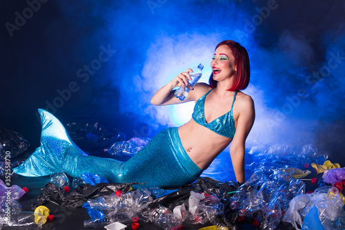 Ocean pollution  rubbish in the water. Stupid fairytale mermaid in dirty ocean. Plastic trash and garbage in water. Environmental problem  plastic bag and bottles polluting planet.