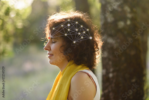 Tableau sur toile Young woman meditating outdoors with neural diagram