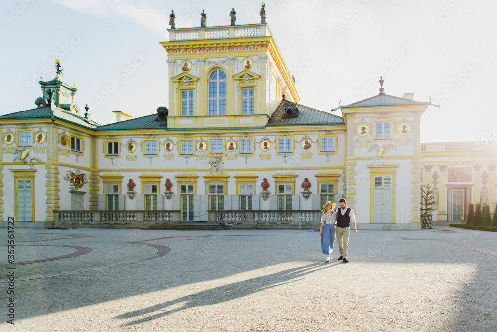 Obraz premium Beautiful young woman and man hug and walk near old castles in Europe.