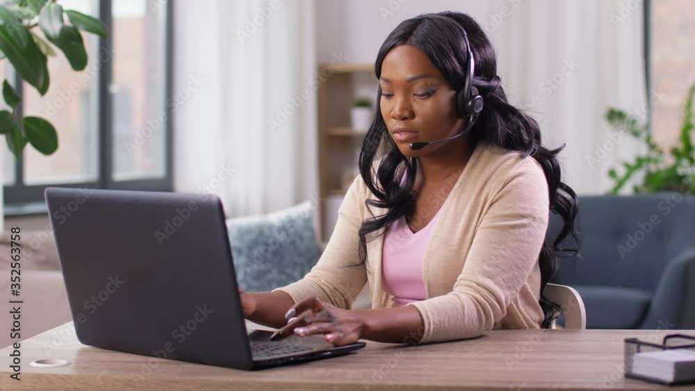 remote job, technology and people concept - african american young woman with headset and laptop computer having call at home office remote job, technology and people concept - african american young woman with headset and laptop computer having call at home office