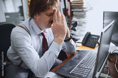 Εκτύπωση καμβά Tired middle-aged businessman overworked with his laptop