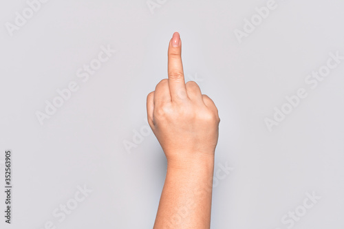 Hand of caucasian young woman showing provocative and rude gesture doing fuck you symbol with middle finger
