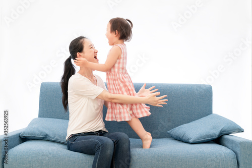 Mother and daughter are playing games on the sofa