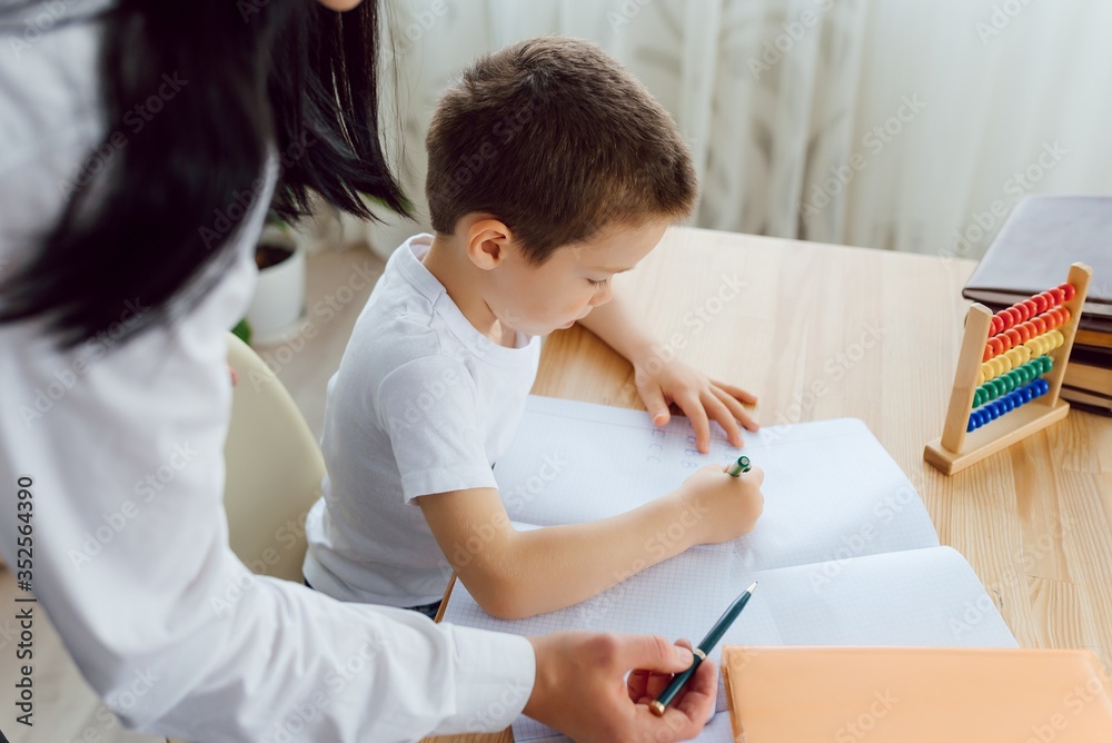 Tutor with pupil. Little boy studying. Private lesson. The concept of private lessons and homework. Tutor with pupil. Little boy studying. Private lesson. The concept of private lessons and homework.
