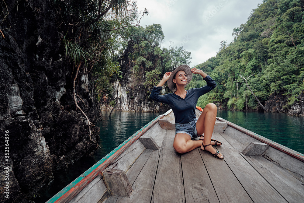 Happy vacation in Thailand. Pretty young woman taking sailing Khao Sok National Park lake on traditional longtail boat. Happy vacation in Thailand. Pretty young woman taking sailing Khao Sok National Park lake on traditional longtail boat.