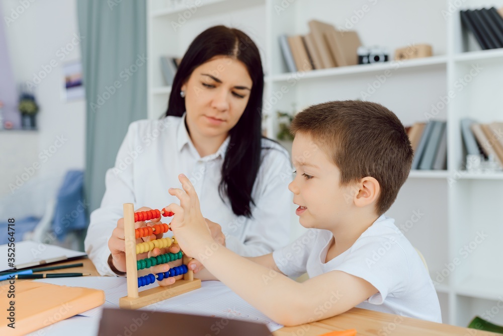 Tutor with pupil. Little boy studying. Private lesson. The concept of private lessons and homework. Tutor with pupil. Little boy studying. Private lesson. The concept of private lessons and homework.