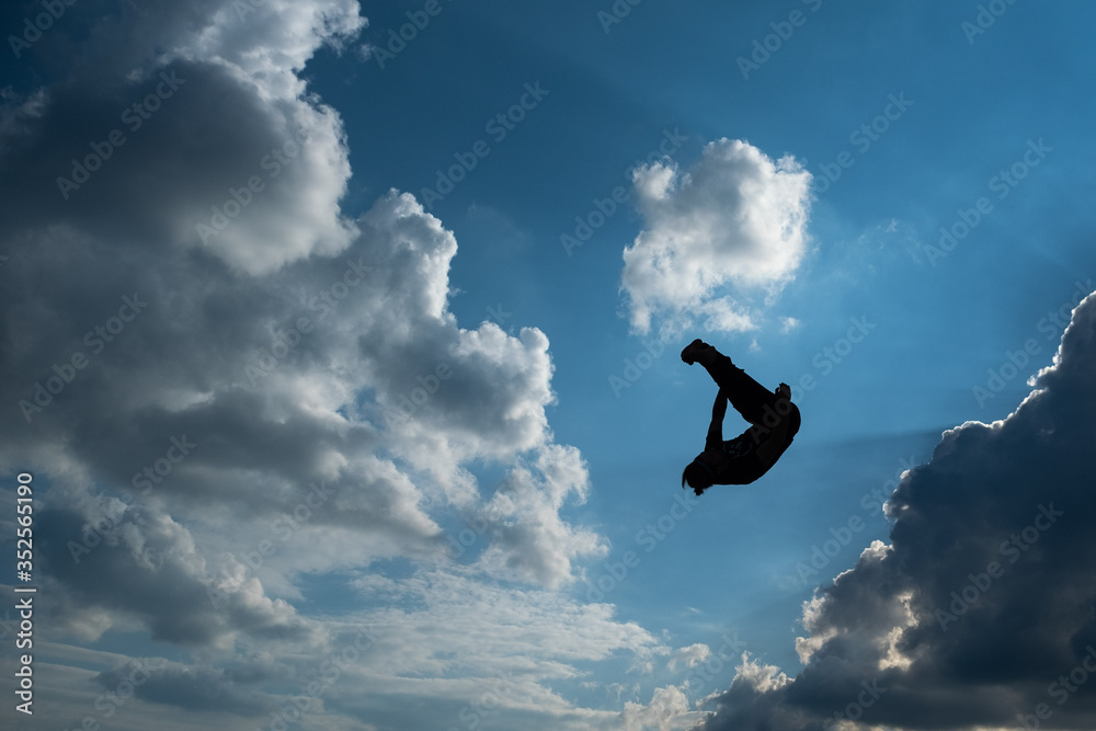 Silhouette of human acrobat with sunny sky in the background Silhouette of human acrobat with sunny sky in the background