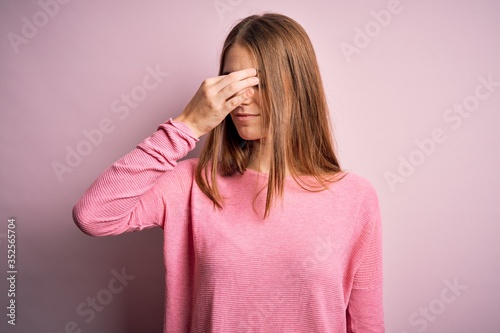 Young beautiful redhead woman wearing casual sweater over isolated pink background tired rubbing nose and eyes feeling fatigue and headache. Stress and frustration concept. © Krakenimages.com