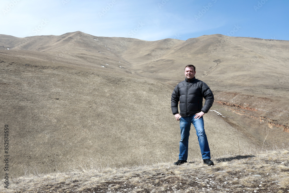 Tourist posing on rocky ridge of Caucasus background