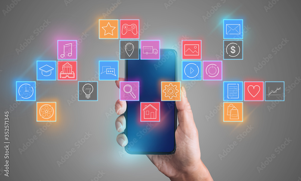Female hand holding smartphone against grey background, collage with functional icons for mobile devices Female hand holding smartphone against grey background, collage with functional icons for mobile devices