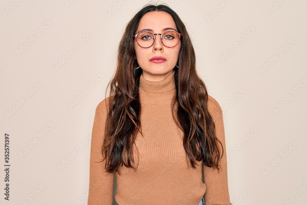 Young beautiful woman wearing casual turtleneck sweater and glasses over white background depressed and worry for distress, crying angry and afraid. Sad expression. Young beautiful woman wearing casual turtleneck sweater and glasses over white background depressed and worry for distress, crying angry and afraid. Sad expression.