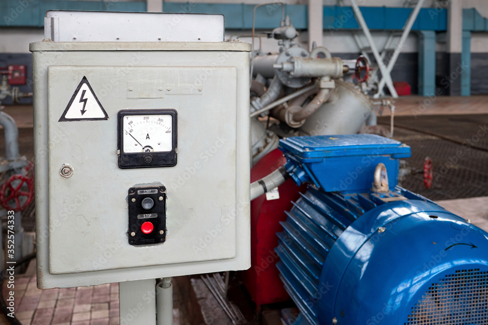Start and Stop button for industrial machine closeup on electric control panel in chemical plant interior near out of focus engine of pump or compressor. Concept of Emergency Stop for safety work. Start and Stop button for industrial machine closeup on electric control panel in chemical plant interior near out of focus engine of pump or compressor. Concept of Emergency Stop for safety work.