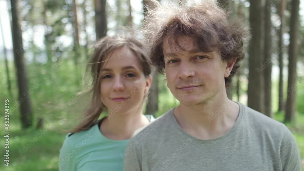 Portrait of the young couple standing outdoor in the sunny forest. Orbiting camera Portrait of the young couple standing outdoor in the sunny forest. Orbiting camera