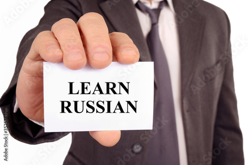 Man holding a card on which is written learn russian