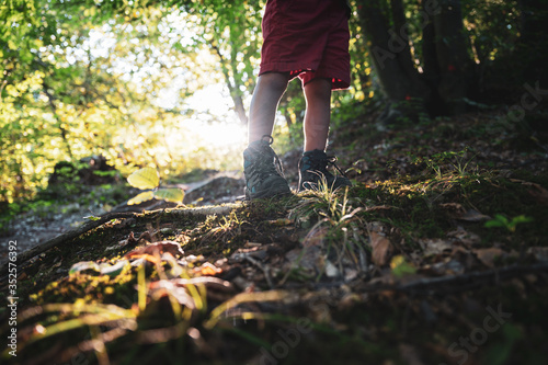 Toddler in hiking shoes standing on hiking trail