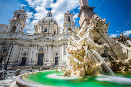 Fountain of rivers in Rome in Italy. In the background, the baroque church of Santa Agnese in Agone. Blue sky. photo