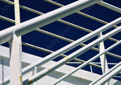 White metal stairs on the ferry. Blue sky background