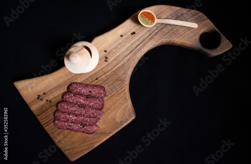 Traditional eastern european food setup. Walnut cutting board, sausage and spices. Bulgaria, balkan food.